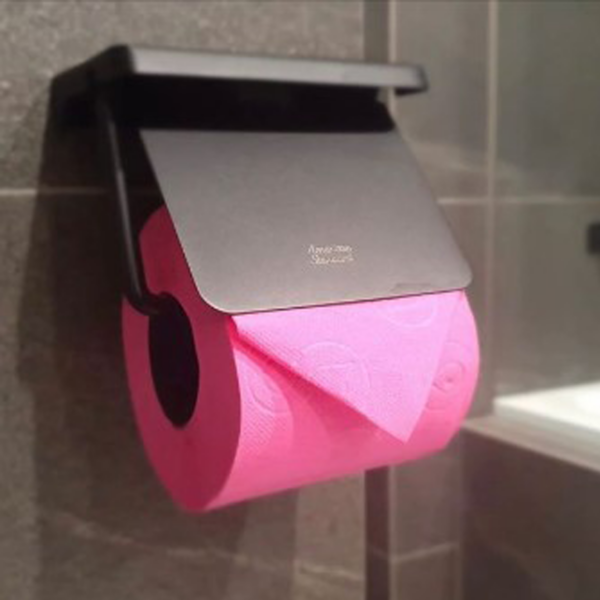 a pink toilet paper roll on a black holder