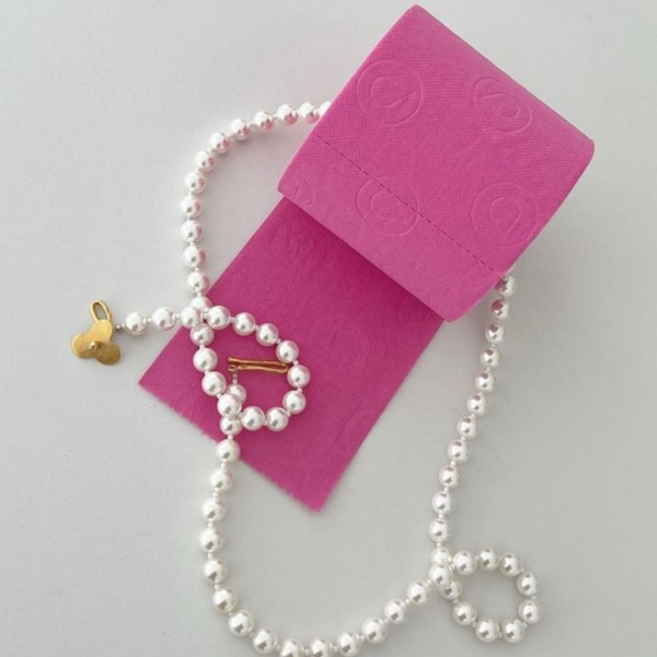 a pink Toilet paper roll with a necklace and a gold clasp