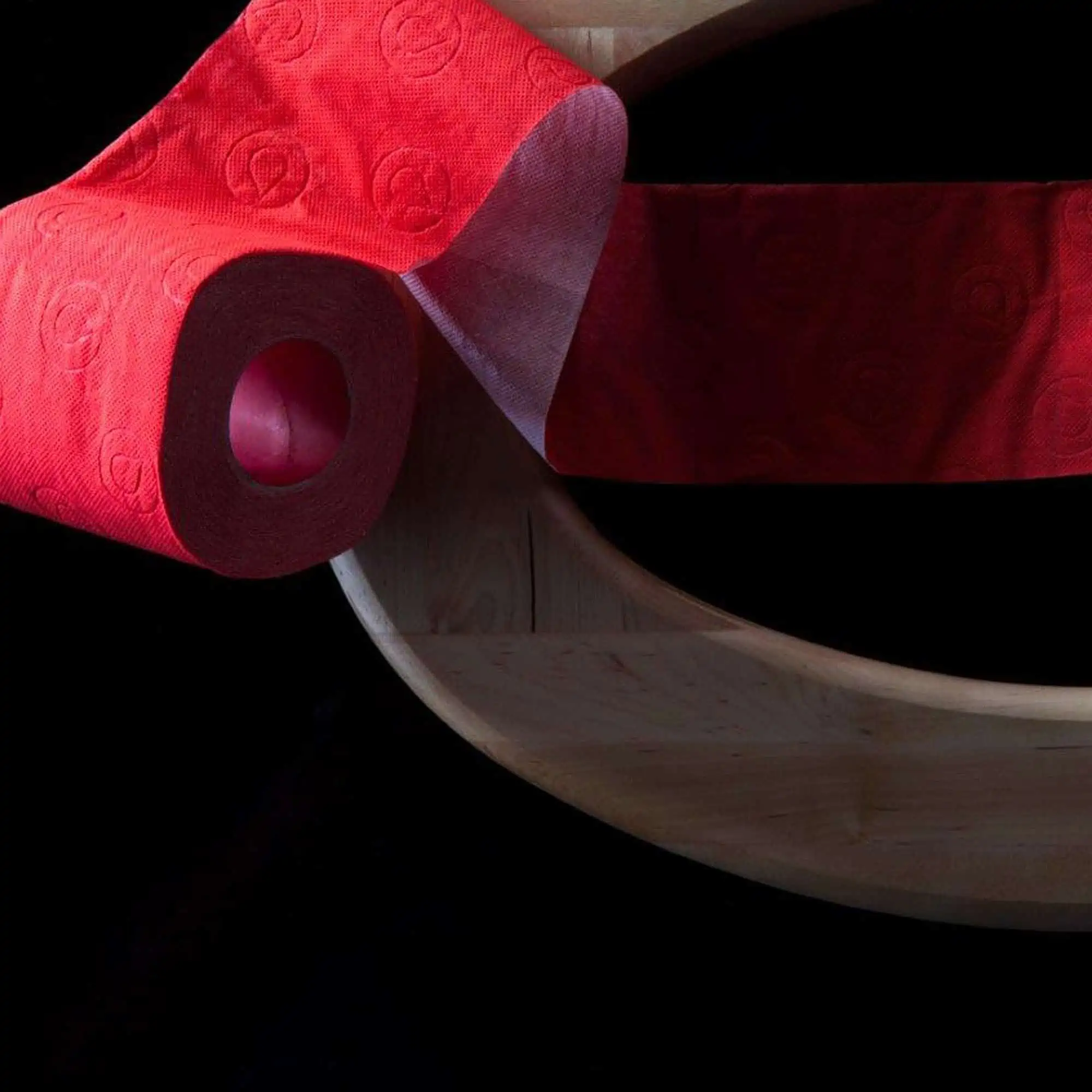 Red Toilet Paper Roll on Wooden Toilet Seat