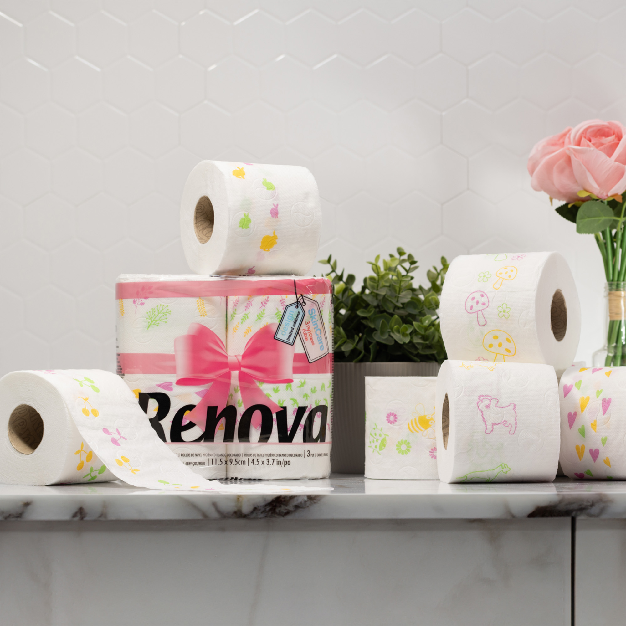 Patterned spring edition toilet paper rolls stacked in a powder room