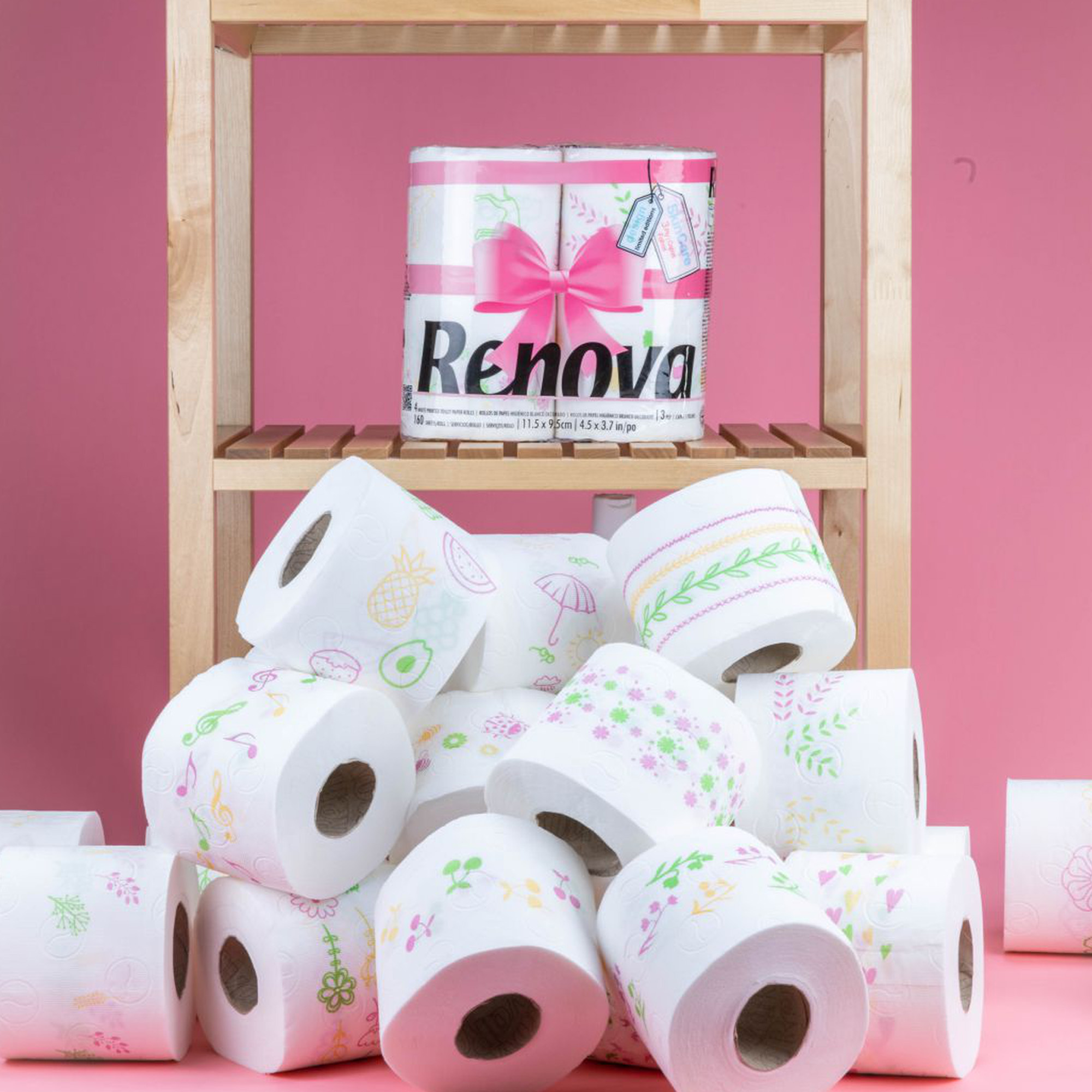 Assorted printed toilet paper designs displayed on a bathroom shelf